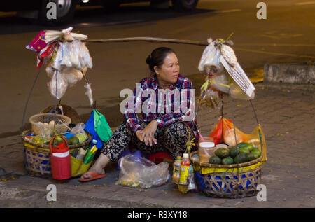 woman selling food on street sidewalk, Saigon, Vietnam. Stock Photo