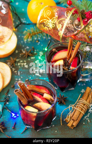 Christmas Mulled Wine or Sangria with Spices. Two glasses of hot mulled wine with Apple and spices on blue slate table. Copy space. Stock Photo