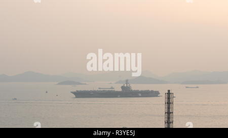 Hong Kong. 24th November 2018. The image represents the aircraft carrier USS Ronald Reagan (CVN 76) anchored near south of the Tsing Yi island in Hong Kong, with some smaller boats near her, the image was shot during sunset on 24 November 2018. Credit: Chun Kit Li/Alamy Live News Stock Photo