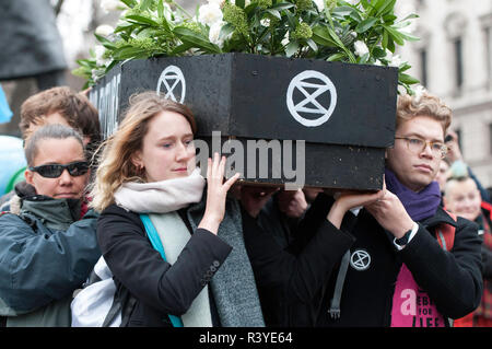 Activists seen carrying a coffin during the march.  Thousands of demonstrators from the new Extinction Rebellion climate change movement gathered at Parliament Square for a memorial and funeral march through London. Demonstrators paid homage to the lives lost due to climate change, and marched carrying a coffin from Parliament Square to Buckingham Palace. Stock Photo