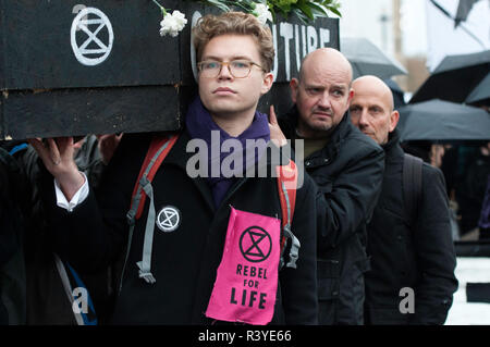 Climate change activists seen carriying a coffin during the protest.  Thousands of demonstrators from the new Extinction Rebellion climate change movement gathered at Parliament Square for a memorial and funeral march through London. Demonstrators paid homage to the lives lost due to climate change, and marched carrying a coffin from Parliament Square to Buckingham Palace. Stock Photo
