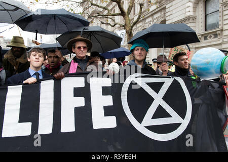 Activists seen carrying a banner during the march.  Thousands of demonstrators from the new Extinction Rebellion climate change movement gathered at Parliament Square for a memorial and funeral march through London. Demonstrators paid homage to the lives lost due to climate change, and marched carrying a coffin from Parliament Square to Buckingham Palace. Stock Photo