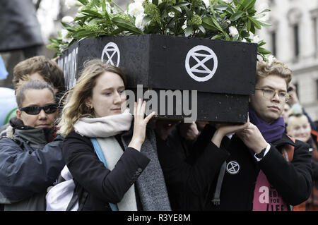 London, Greater London, UK. 24th Nov, 2018. Activists seen carrying a coffin during the march.Thousands of demonstrators from the new Extinction Rebellion climate change movement gathered at Parliament Square for a memorial and funeral march through London. Demonstrators paid homage to the lives lost due to climate change, and marched carrying a coffin from Parliament Square to Buckingham Palace. Credit: Andres Pantoja/SOPA Images/ZUMA Wire/Alamy Live News Stock Photo
