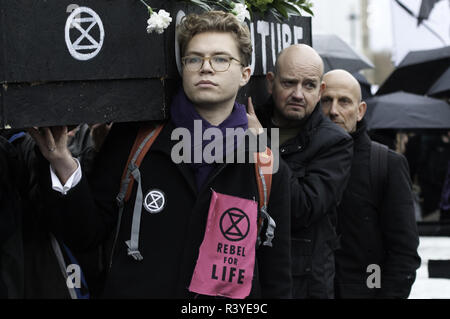 London, Greater London, UK. 24th Nov, 2018. Climate change activists seen carriying a coffin during the protest.Thousands of demonstrators from the new Extinction Rebellion climate change movement gathered at Parliament Square for a memorial and funeral march through London. Demonstrators paid homage to the lives lost due to climate change, and marched carrying a coffin from Parliament Square to Buckingham Palace. Credit: Andres Pantoja/SOPA Images/ZUMA Wire/Alamy Live News Stock Photo