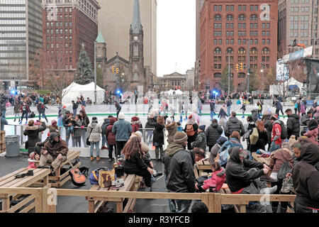 Cleveland, Ohio, USA. 24th Nov, 2018.  Visitors to downtown Public Square in Cleveland, Ohio enjoy free ice skating during the 36th Annual Cleveland Winterfest.  Skaters switch skates and shoes next to the man-made outdoor ice rink as spectators line the rink watching people skate.  This family-friendly festival is the unofficial kick-off of the Christmas holiday season with events throughout Public Square and throughout downtown Cleveland, Ohio, USA.  Credit: Mark Kanning/Alamy Live News. Stock Photo
