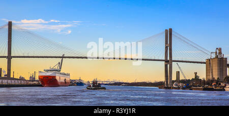 Savannah, Georgia. Tug boat and container ship on Savannah River next to Talmadge Bridge Stock Photo