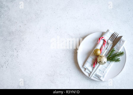 Christmas Table Setting on white table with golden balls, copy space. Christmas dinner, party design, concept. Stock Photo
