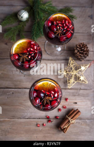 Red Sangria with oranges, pomegranate seeds, cranberry, rosemary and spices - homemade festive drink mulled wine for Christmas time. Stock Photo