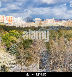 storm clouds over city and first snow on woods Stock Photo
