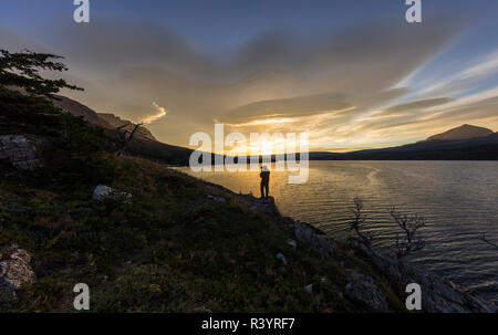 Photographer silhouetted against the sunrise over St. Mary Lake Glacier National Park, Montana, USA Stock Photo