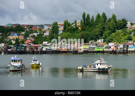 Fishing boats anchoring in front of colorful stilt houses, pile dwellings, called palafitos, Castro, island Chiloé, Chile Stock Photo