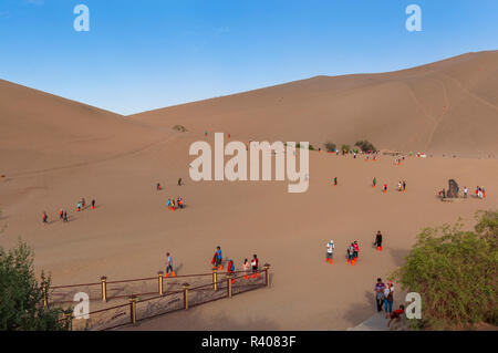 Dunhuang, China - August 8, 2012: Group of Chinese tourists at the Crescent Moon Lake near the city of Dunhuang, in the Gansu Province, China.