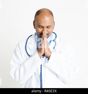 Mature Indian doctor praying Stock Photo