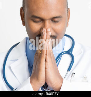 Close up Mature Indian doctor praying Stock Photo