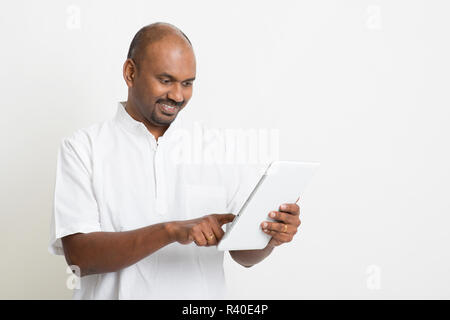 Mature casual business Indian man using tablet pc Stock Photo
