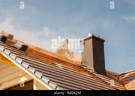 Roofer working on the top of the unfinished roof Stock Photo