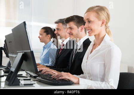 Businesspeople Typing On Desktop Computer Stock Photo
