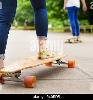 Teenage girl practicing riding long board. Stock Photo