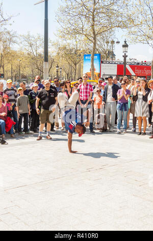 PARIS, FRANCE -  APRIL 25:B-boy doing some breakdance moves in front a street crowd, at Arch of Triumph on april 25, 2013 in Paris. Its popular form o Stock Photo