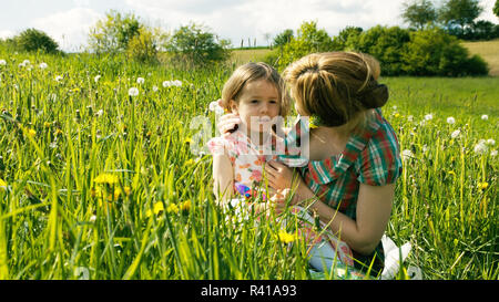 the mother consoles her daughter on a spring meadow - part 1 Stock Photo