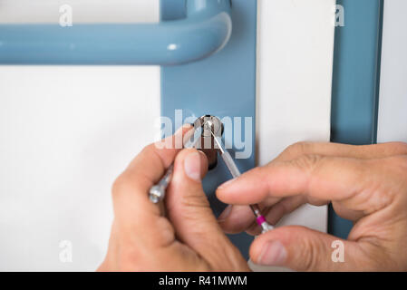 Lockpicker Fixing Door Handle At Home Stock Photo