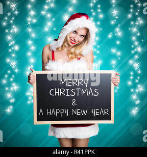 attractive miss santa with a blackboard and merry christmas message Stock Photo