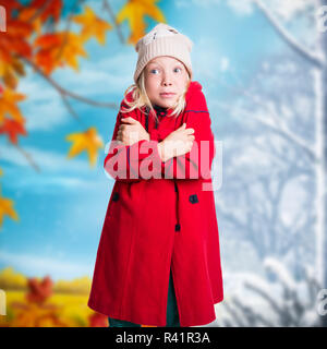 young girl in winter clothes in front of changing season background Stock Photo
