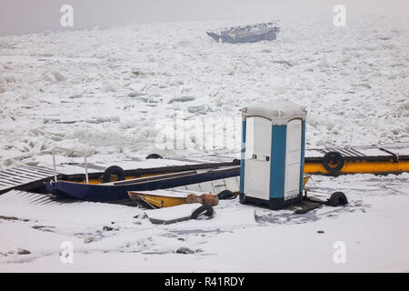 Fishing boat in a frozen river Stock Photo