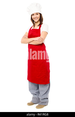 Young beautiful baker woman wearing apron uniform cooking over yellow