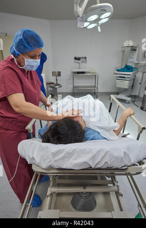 Nurse helping to patient laying in clinic bed Stock Photo