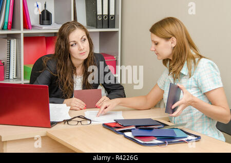 Girl shows resume employer, the employer wary looks at her Stock Photo