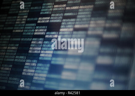block of binary data code defocus foreground and focus in the background. digital led computer screen displaying digits of one and zero on dark blue p Stock Photo