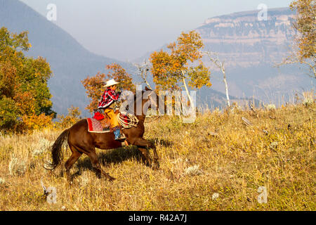 USA, Wyoming, Shell, The Hideout Ranch, Young Cowboy Riding in the Hills (MR, PR) Stock Photo