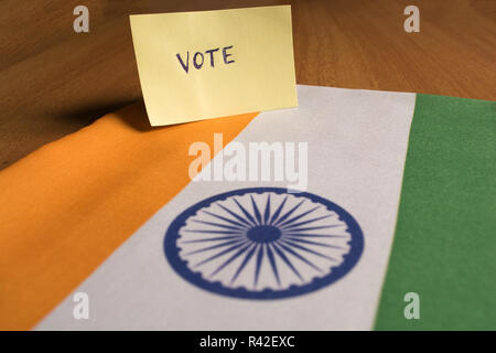 Voting concept - Hand Written Voting Sticker on Indian Flag. Stock Photo