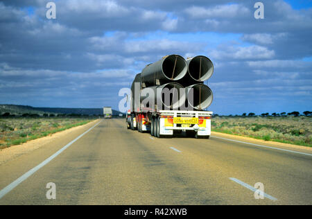 Road train transporting large water pipes, Australia Stock Photo