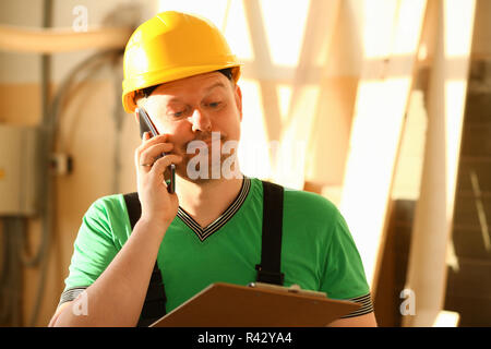 Carpenter talking on phone in hardware store Stock Photo