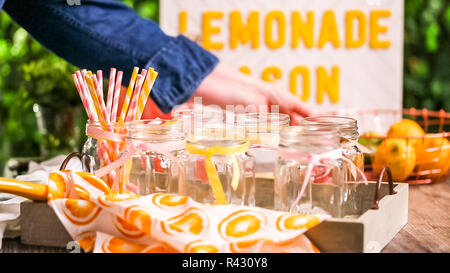Raspberry lemonade garnished with fresh lemon and raspberries in drinking mason jars. Stock Photo