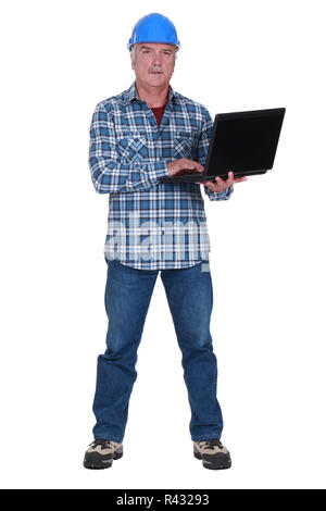 Tradesman holding a laptop Stock Photo