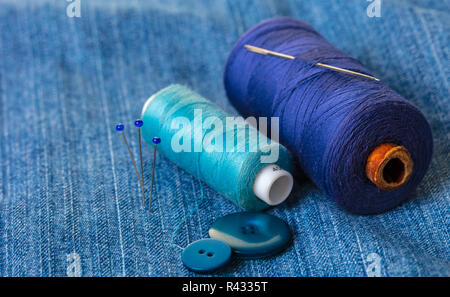 blue threads with buttons on the background of denim Stock Photo