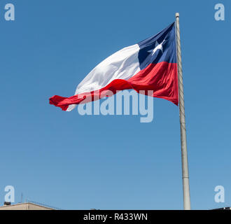 Flag of Chile developing against a clear blue sky. Patriotic symbol of Chile, South America. Stock Photo