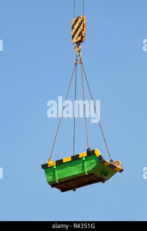 Green builders skip in the air Stock Photo