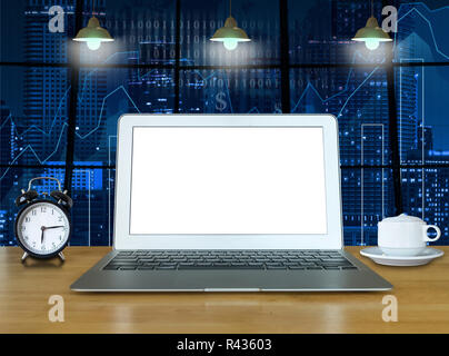 Workspace with computer laptop on the wood table with the windows which shown trading graph on the blurred photo of cityscape building background, tra Stock Photo