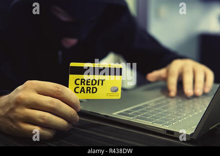 Unknown person uses computer and credit card to commit cyber crime. Computer trespasser uses internet to steal money. Drawing money from banking accou Stock Photo