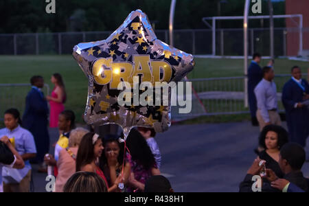 Middletown, CT USA. Jun 2013. High school graduation balloon in the foreground of happy and celebrating African American seniors in this special day. Stock Photo