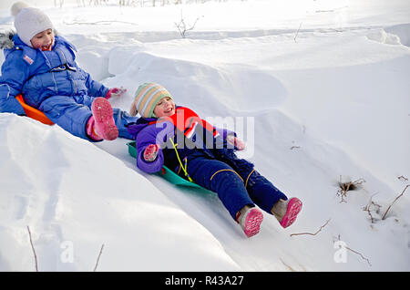 Happy little girls rolling down the hill on the playground Stock Photo ...