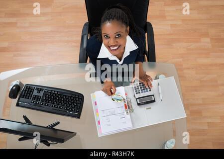 Businesswoman Looking Through Magnifying Glass Stock Photo