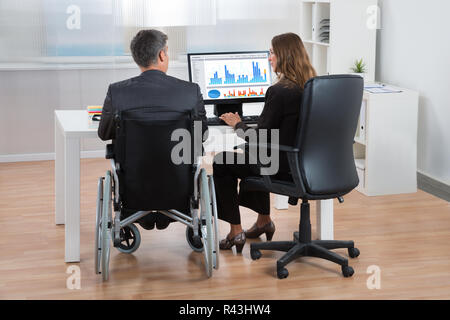 Businesspeople Analyzing Graph On Computer Stock Photo