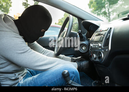 Thief With Mask Sitting In A Car Stock Photo