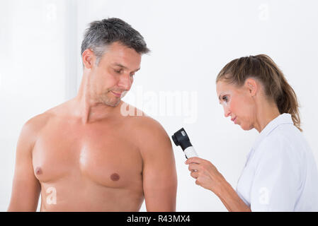 Doctor Examining Pigmented Skin Of Patient Stock Photo