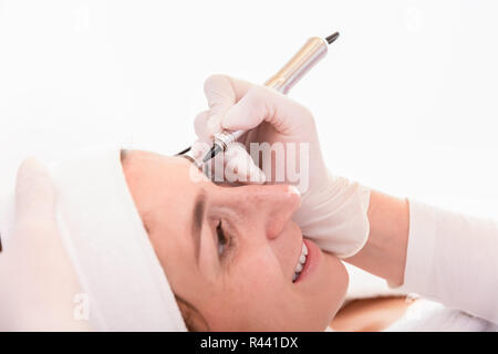 Smiling woman in beauty salon for eyebrow treatment Stock Photo